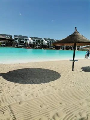 a beach with an umbrella and the water at The Blyde Crystal Lagoon in Pretoria