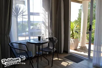 a table and two chairs in front of a window at Misty View Apartments in Dullstroom