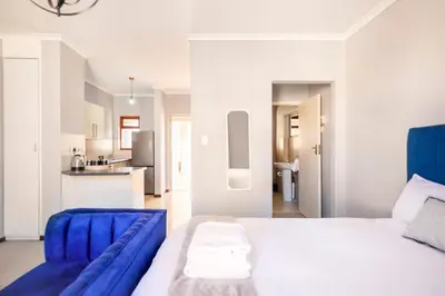 a bedroom with a large bed and a kitchen at Budget-Friendly & Cozy Haven by BK Hospitable in Midrand