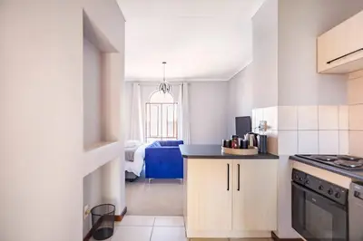 a kitchen with a counter and a room with a bed at Budget-Friendly & Cozy Haven by BK Hospitable in Midrand
