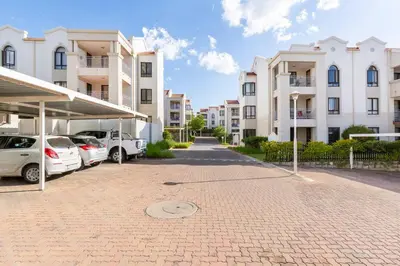 a parking lot with cars parked in front of buildings at Budget-Friendly & Cozy Haven by BK Hospitable in Midrand