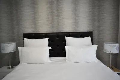 a bed with white pillows and two lamps at Candymore luxury apartment in Midrand