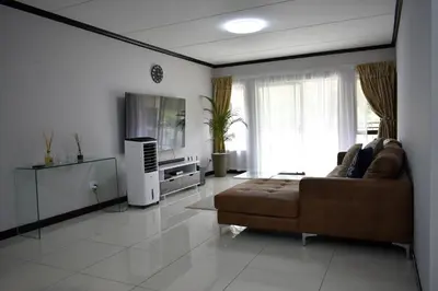 a living room with a couch and a flat screen tv at Candymore luxury apartment in Midrand