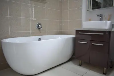 a bathroom with a white bath tub and a sink at Candymore luxury apartment in Midrand