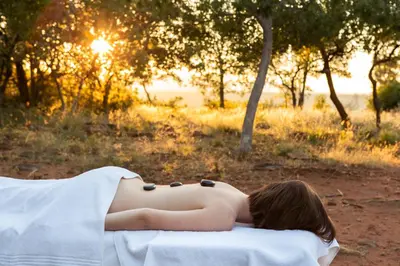 a woman laying on a towel with the sun in the background at Jembisa Bush Home in Melk River