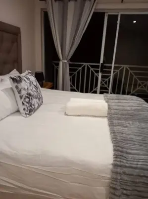 a white bed with a pillow and a window at 3 bedroom self catering @ Lelapa La Baphogole in Pretoria