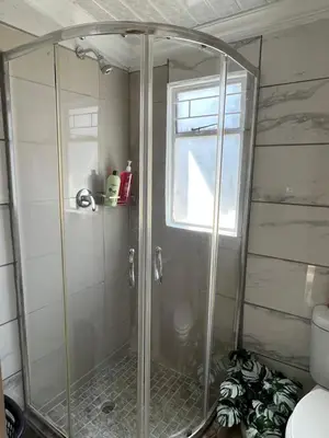 a shower with a glass door in a bathroom at 17 Byvanger Luxury Home Deluxe Queen Suite Room 1 in Centurion