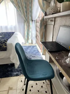 a green chair sitting in front of a desk with a laptop at 17 Byvanger Luxury Home Deluxe Queen Suite Room 1 in Centurion