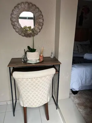 a table with a chair and a mirror on a wall at 17 Byvanger Luxury Home Deluxe Queen Suite Room 1 in Centurion