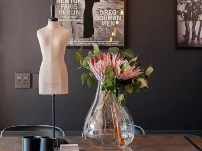a vase with flowers on a table next to a mannequin at Milner Fashion House in Pretoria