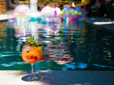 a drink in a glass next to a swimming pool at Milner Fashion House in Pretoria