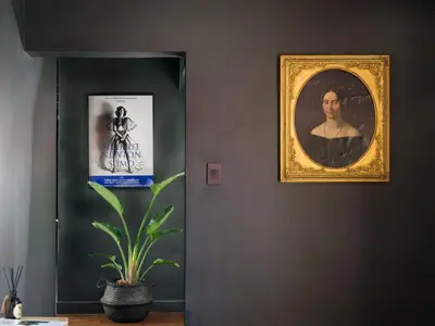 a framed portrait of a man on a wall with a plant at Milner Fashion House in Pretoria