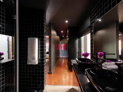a bathroom with three sinks and black tiles at Milner Fashion House in Pretoria