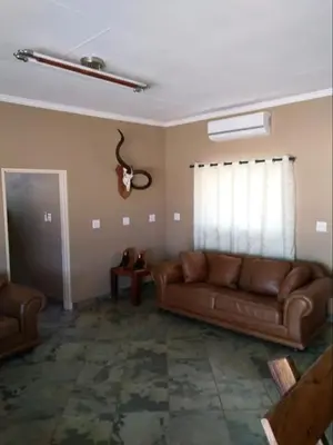 a living room with a brown couch and a window at Marocco Lodge in Baltimore
