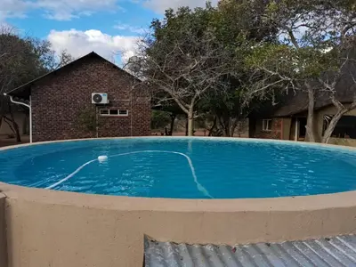 a large blue swimming pool in front of a house at Marocco Lodge in Baltimore