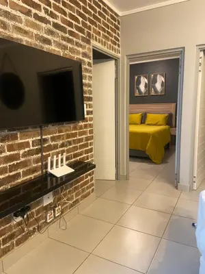 a bedroom with a bed and a brick wall at Green Valley Bliss in Boschrand