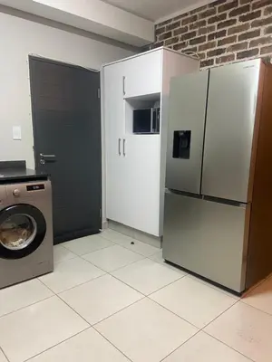 a kitchen with a refrigerator and a washing machine at Green Valley Bliss in Boschrand