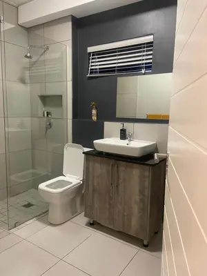 a bathroom with a toilet and a sink and a shower at Green Valley Bliss in Boschrand