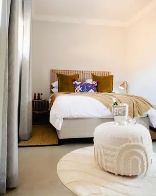 a bedroom with a bed and a table in front of it at The Lofts @ Ivy Lane in Dullstroom