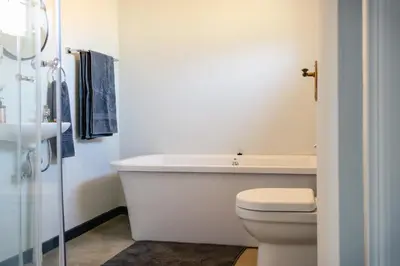 a white bathroom with a tub and a toilet at The Lofts @ Ivy Lane in Dullstroom