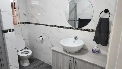 a bathroom with a sink and a toilet and a mirror at SABLE INN B&B in Modimolle