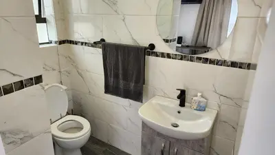 a white bathroom with a toilet and a sink at SABLE INN B&B in Modimolle