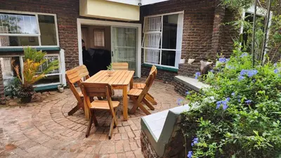 a wooden table and chairs on a brick patio at SABLE INN B&B in Modimolle