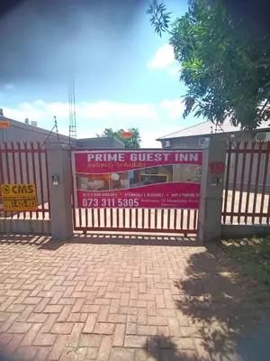 a fence with a sign that reads prime guest inn at Prime Guest Inn in Benoni