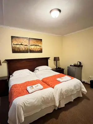 a bedroom with a large bed with two towels on it at Limpopo Guest Manor in Polokwane