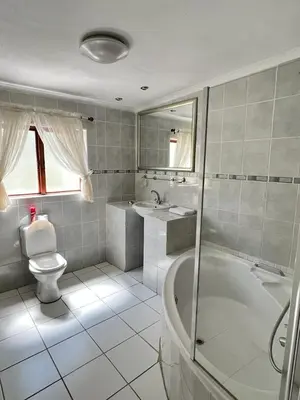 a bathroom with a tub and a toilet and a sink at Limpopo Guest Manor in Polokwane