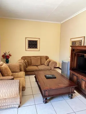 a living room with a couch and a coffee table at Limpopo Guest Manor in Polokwane