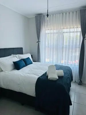 a bedroom with a large bed and a window at Lagoon facing The Blyde in Pretoria