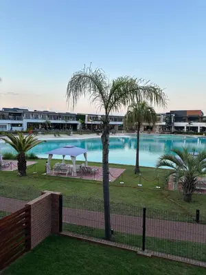 a view of a large swimming pool with palm trees at Lagoon facing The Blyde in Pretoria