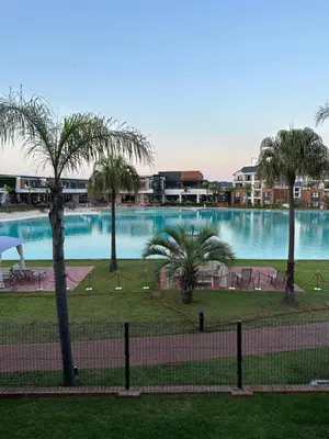 a view of a large swimming pool with palm trees at Lagoon facing The Blyde in Pretoria