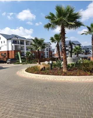 a cobblestone street with palm trees and buildings at Lagoon facing The Blyde in Pretoria