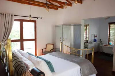 a bedroom with a bed and a tub and a sink at The Blue Place in Pretoria