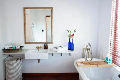 a bathroom with a sink and a mirror and a tub at The Blue Place in Pretoria