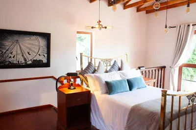 a bedroom with a bed with white sheets and blue pillows at The Blue Place in Pretoria