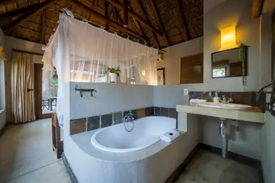 a bathroom with a bath tub and a sink at Raptors Lodge in Hoedspruit