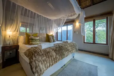 a bedroom with a large bed with a canopy at Raptors Lodge in Hoedspruit