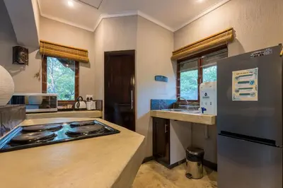 a kitchen with a stove and a refrigerator at Raptors Lodge in Hoedspruit