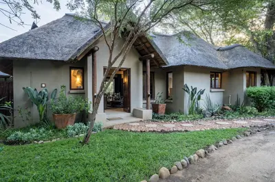 a small house with a thatched roof at Raptors Lodge in Hoedspruit