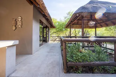 a porch of a building with a thatch roof at Raptors Lodge in Hoedspruit