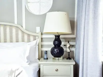 a lamp on a night stand next to a bed at C'est La Vie Boutique Hotel in Witbank