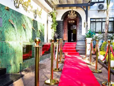 a red carpeted aisle with red chairs and a wall at C'est La Vie Boutique Hotel in Witbank