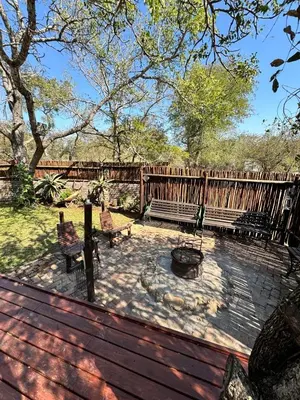 a patio with two benches and a fire hydrant at Vuurvliegie in Marloth Park