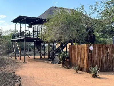 a house with a deck and a fence at Vuurvliegie in Marloth Park