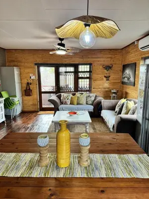 a living room with a couch and a table at Sonbesie in Marloth Park