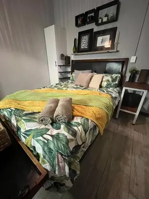 a bedroom with a large bed with pillows on it at Kiewiets Creek Guesthouse in Pretoria