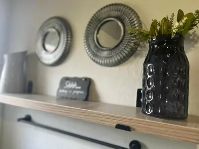 a black vase sitting on a shelf with two plates at Kiewiets Creek Guesthouse in Pretoria